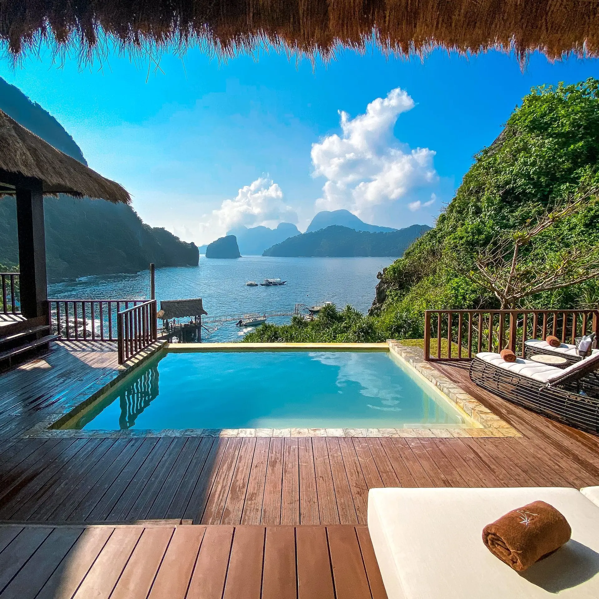 A villa pool and wooden terrace overlooking the sea at Cauayan Island Resort