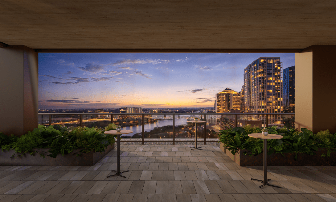 The hotel terrace at blue hour, looking out over Lady Bird Lake and the lit skyline.