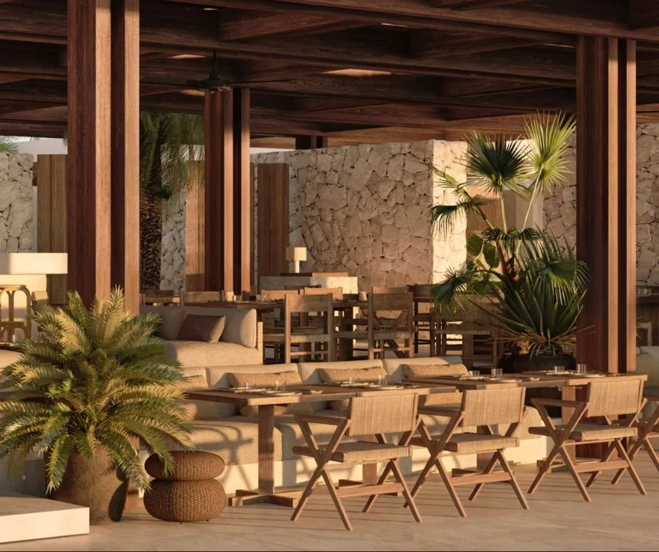 The open-sided dining room at Luura Cliff, timber columns and stone walls in late afternoon light.