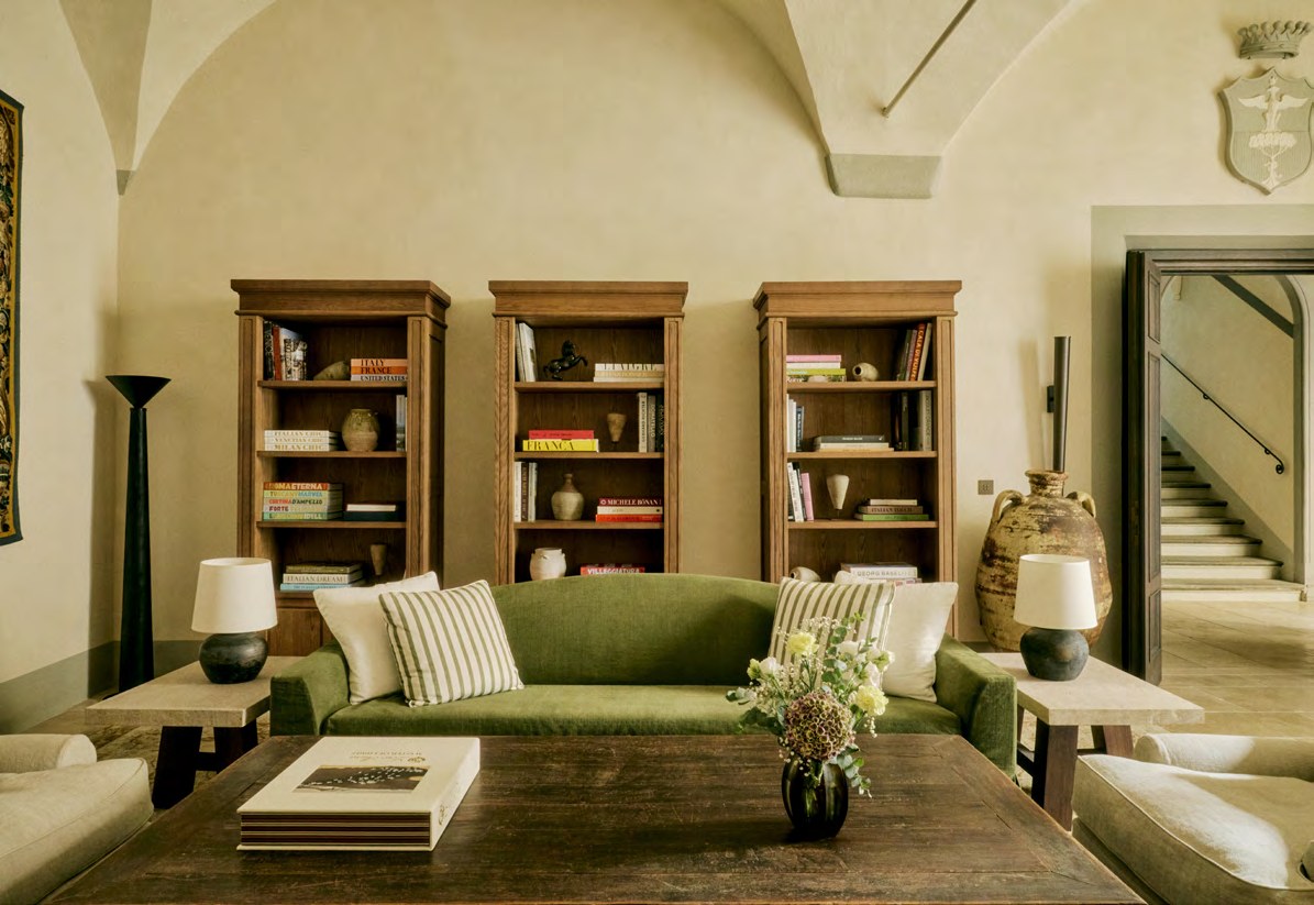 The library at La Réserve Firenze, with oak bookcases under a vaulted ceiling.