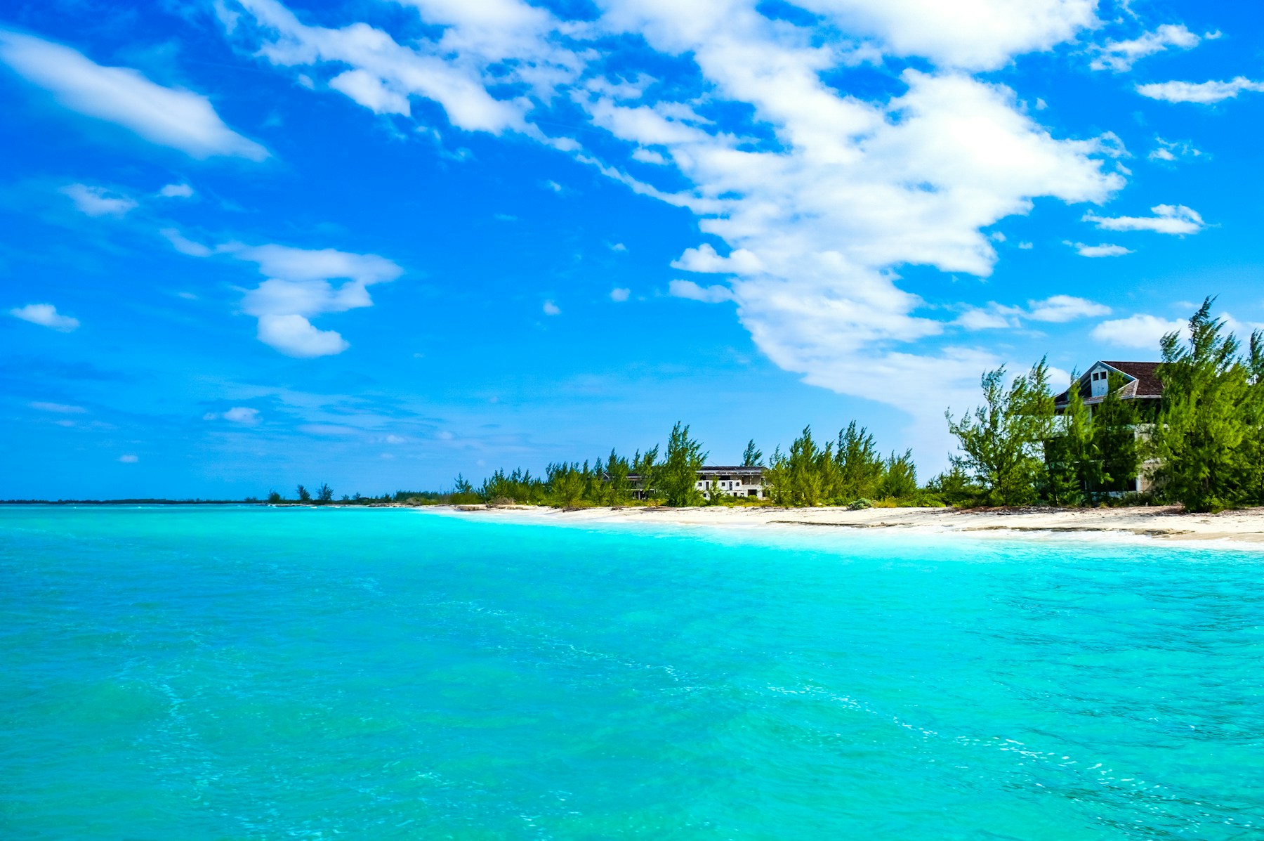 A quiet white-sand beach and clear Caribbean water.