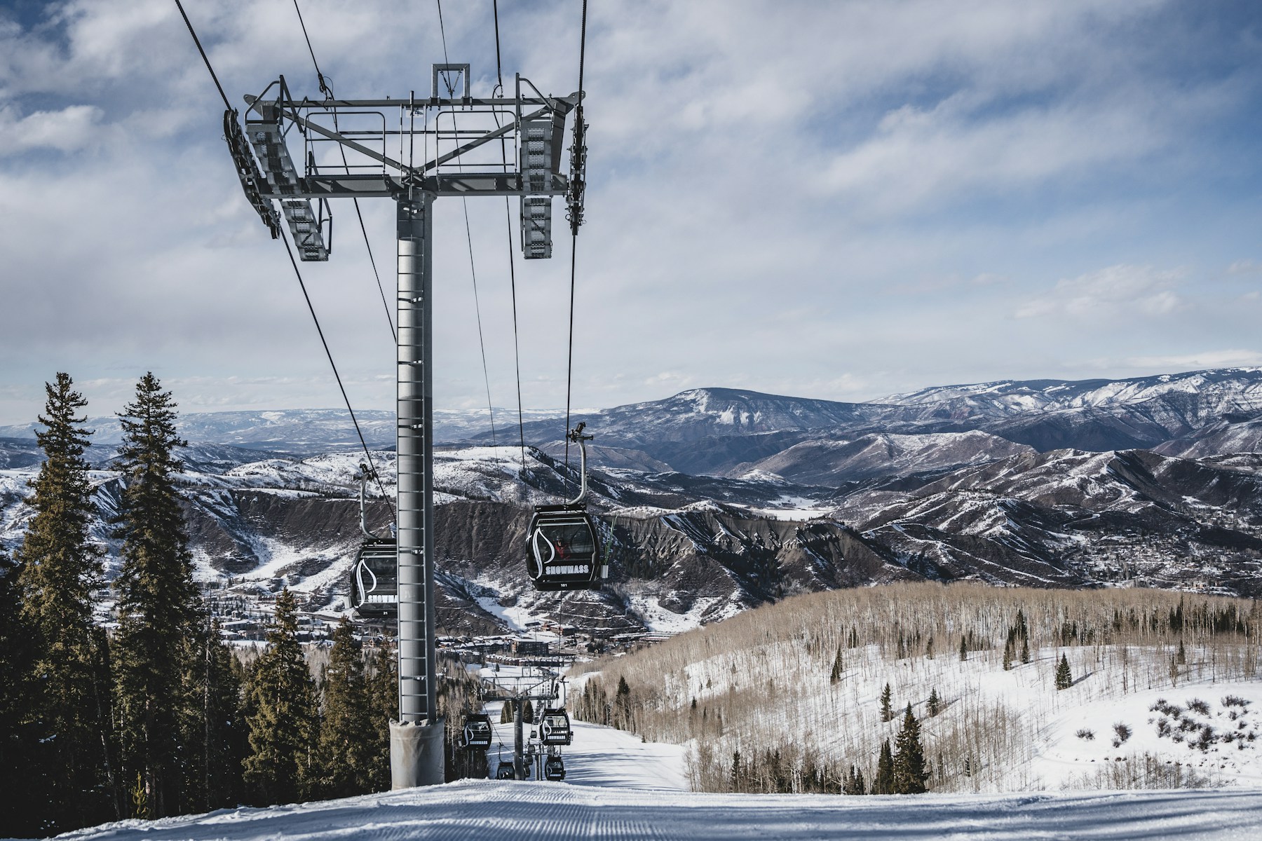 Skiers and snowy mountains near Aspen, Colorado.