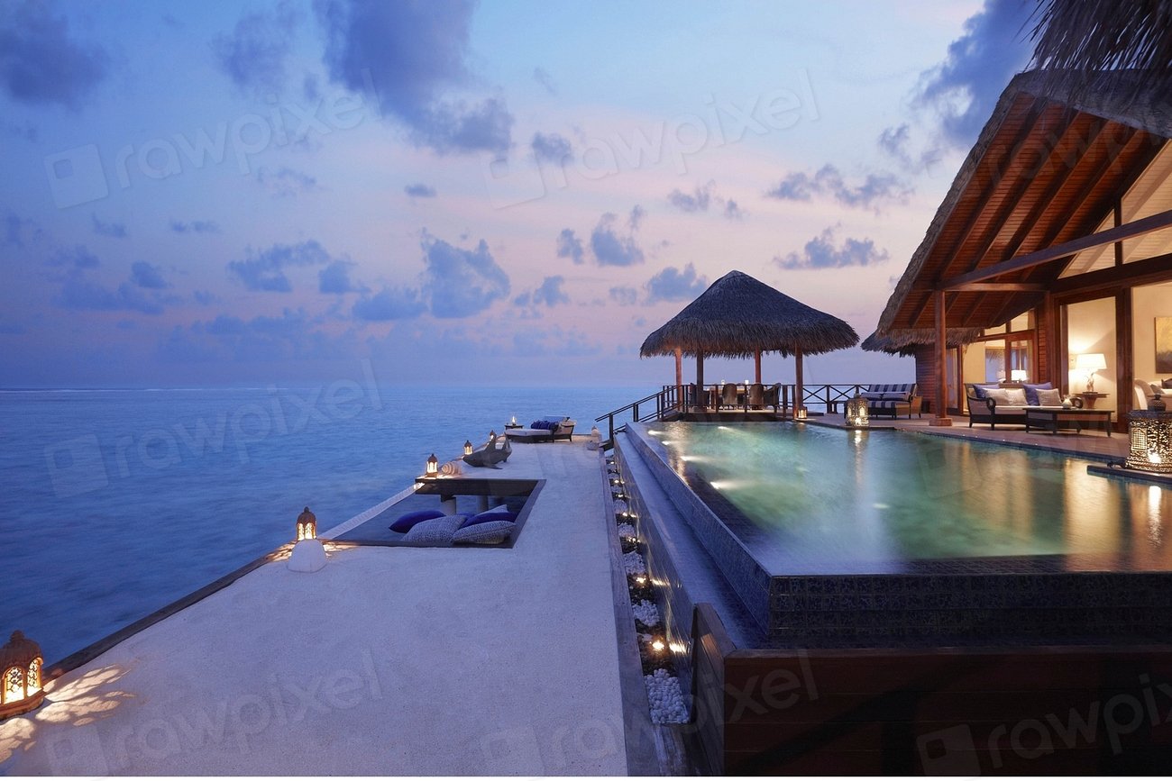 A beachfront resort pool at dusk on the Gulf of Thailand